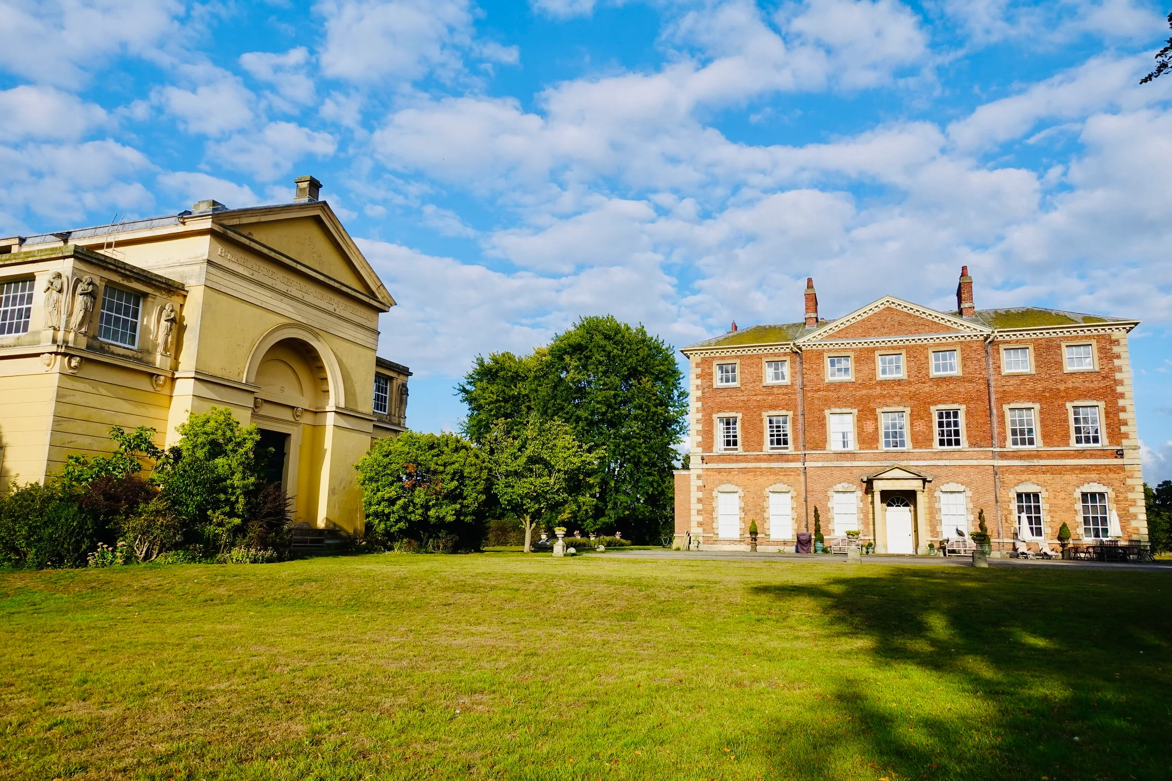The Hall and the adjoining Romanesque Chapel of St Mary and St Everilda, photographed from the lawn at Everingham Park under a bright summer sky.